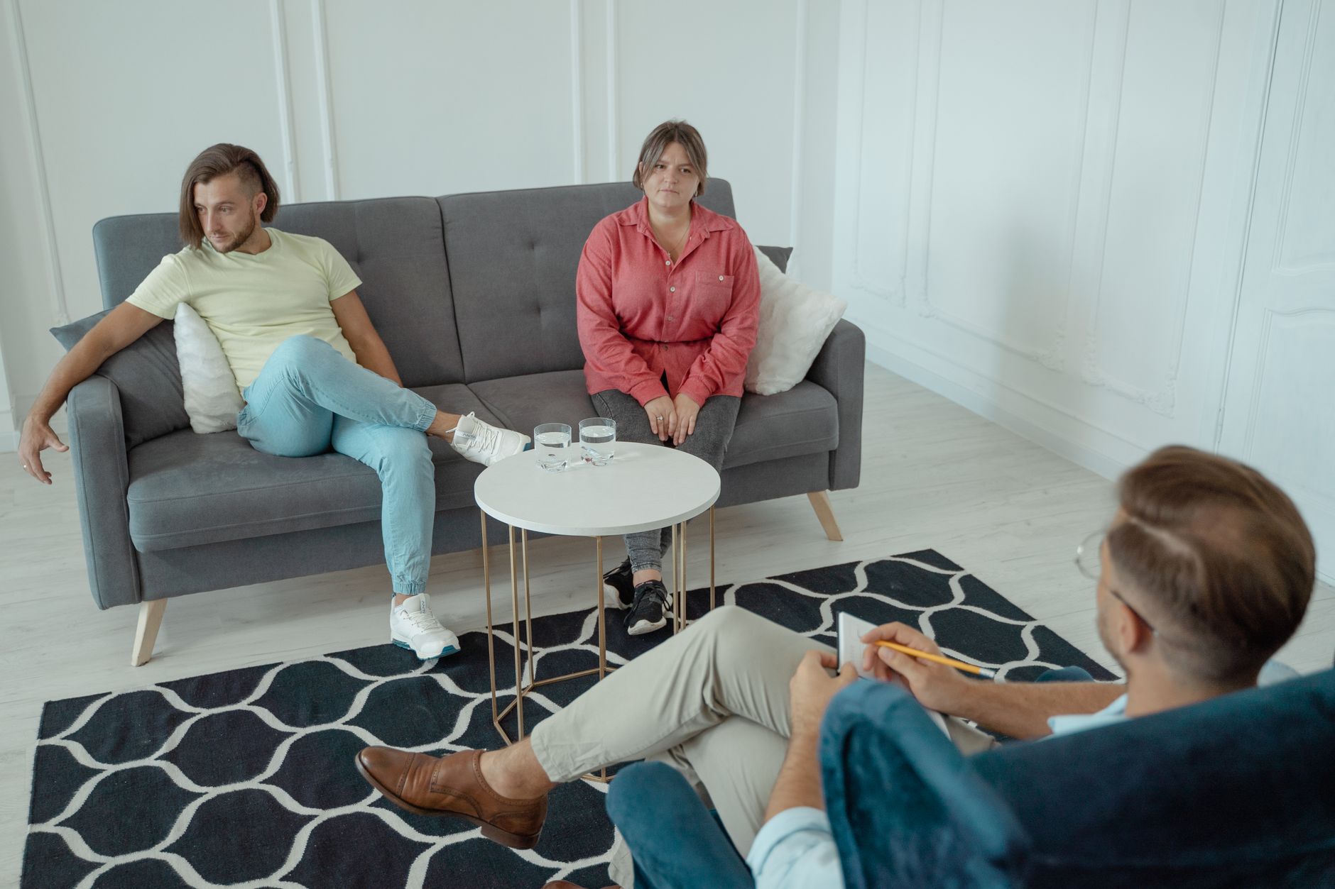 A couple sitting on a sofa during a session with a counselor